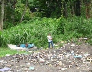 Child standing amongst rubbish in Tibas slum, Costa Rica